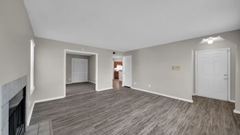 A spacious living room with a fireplace and hardwood flooring. at The Local Apartments, Memphis